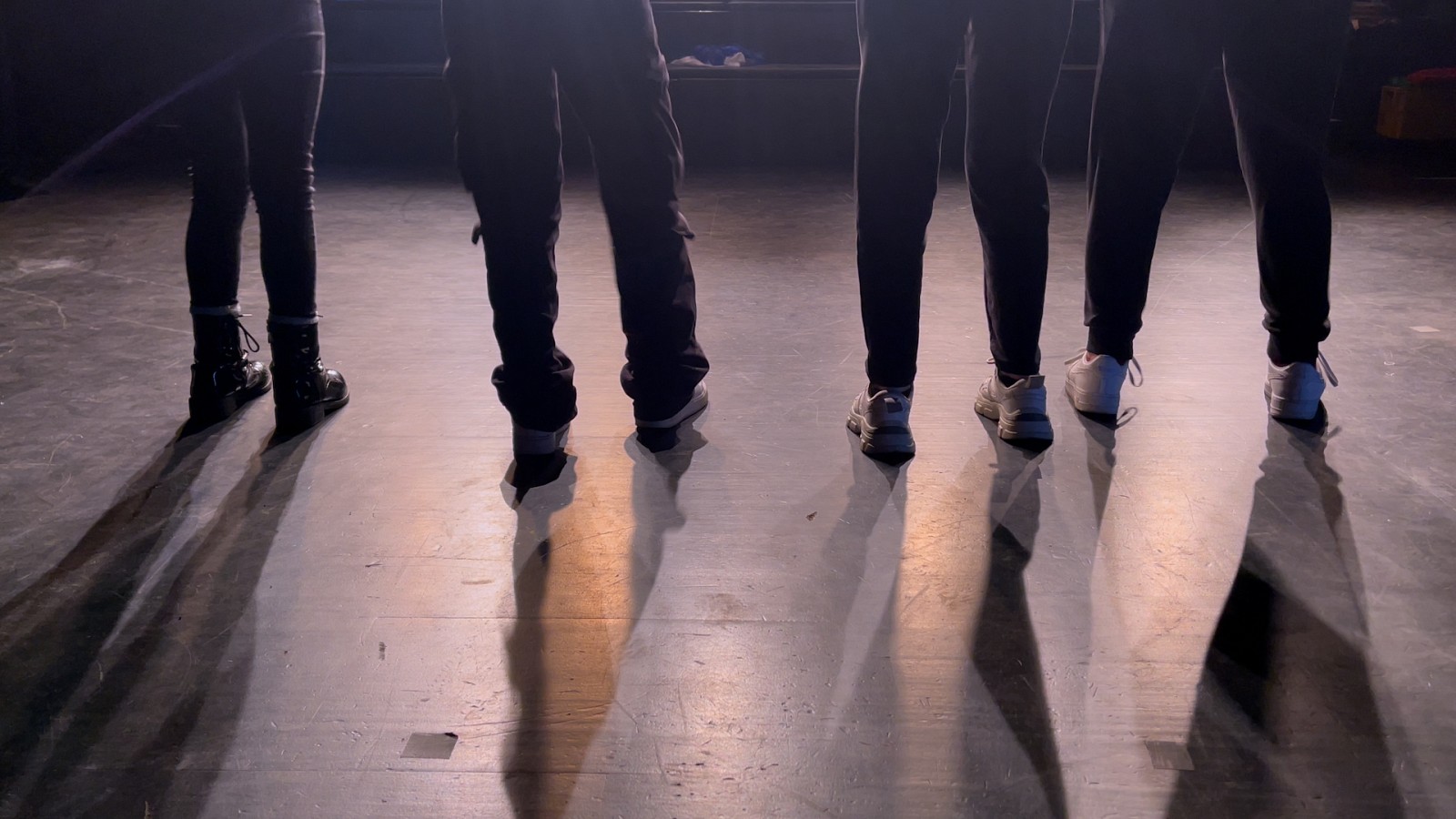 Illuminated on stage, 8 legs stand in the spotlight